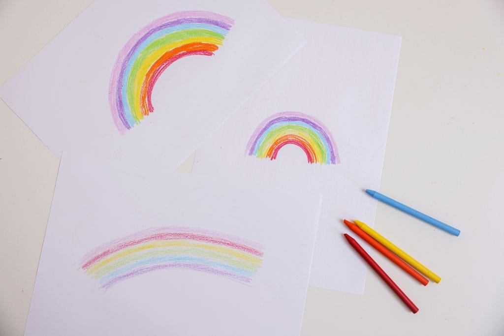 Vibrant crayon rainbow drawings on paper, viewed from above. Perfect for artistic and creative themes.